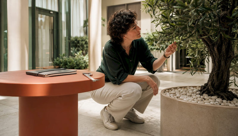 Fachmann begutachtet UV-beständigen Kunstbaum in der Hotellobby
