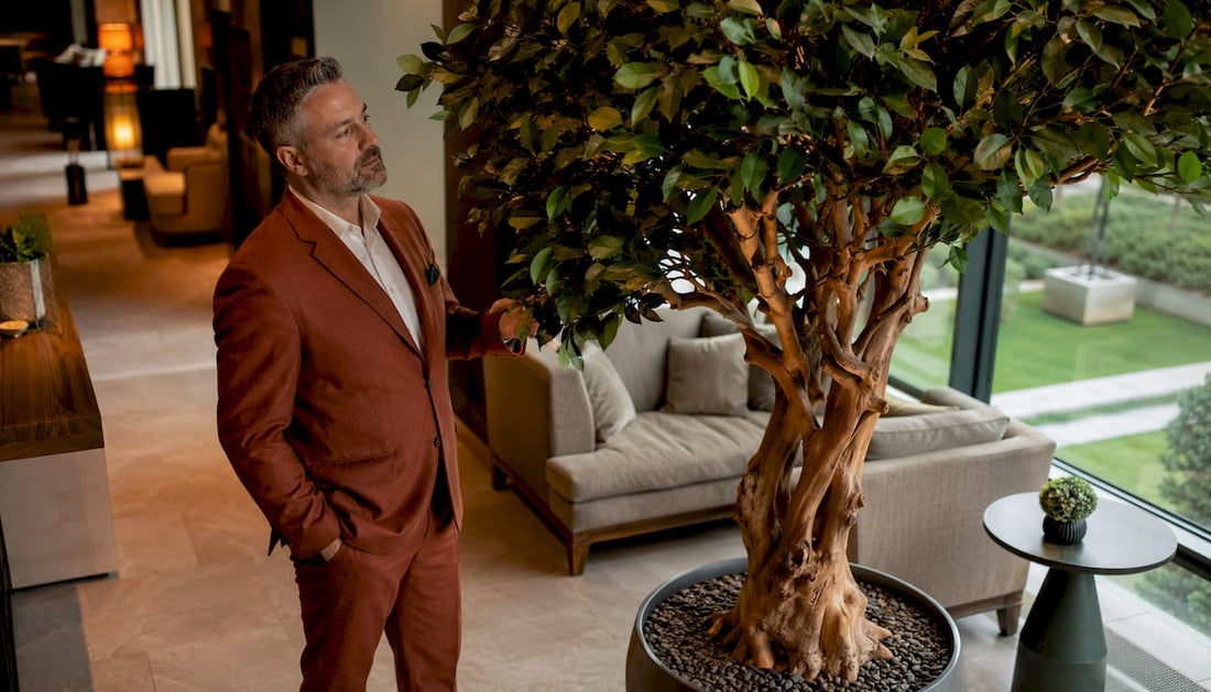 Der Hotelmanager begutachtet den täuschend echten Kunstbaum in der Hotellobby.