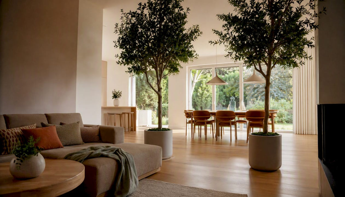 Ein künstlicher Baum als Raumteiler sorgt im Wohnzimmer für eine stilvolle Trennung und bringt gleichzeitig ein bisschen Grün ins Zuhause.