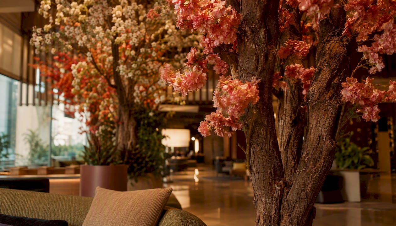 Prächtige Kunstblütenbäume als eleganter Blickfang in der Hotellobby