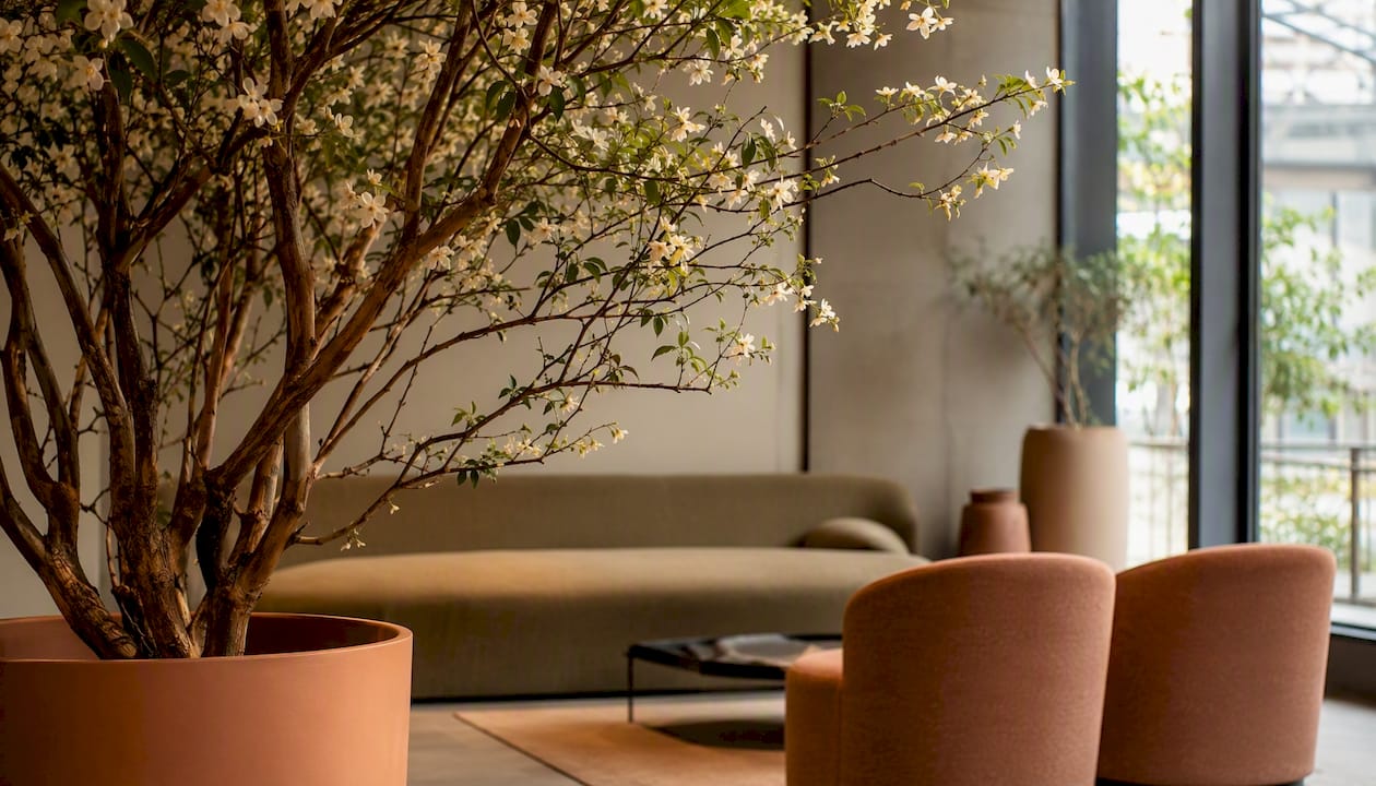 In einer Ecke der Hotellobby steht ein künstlicher Baum.