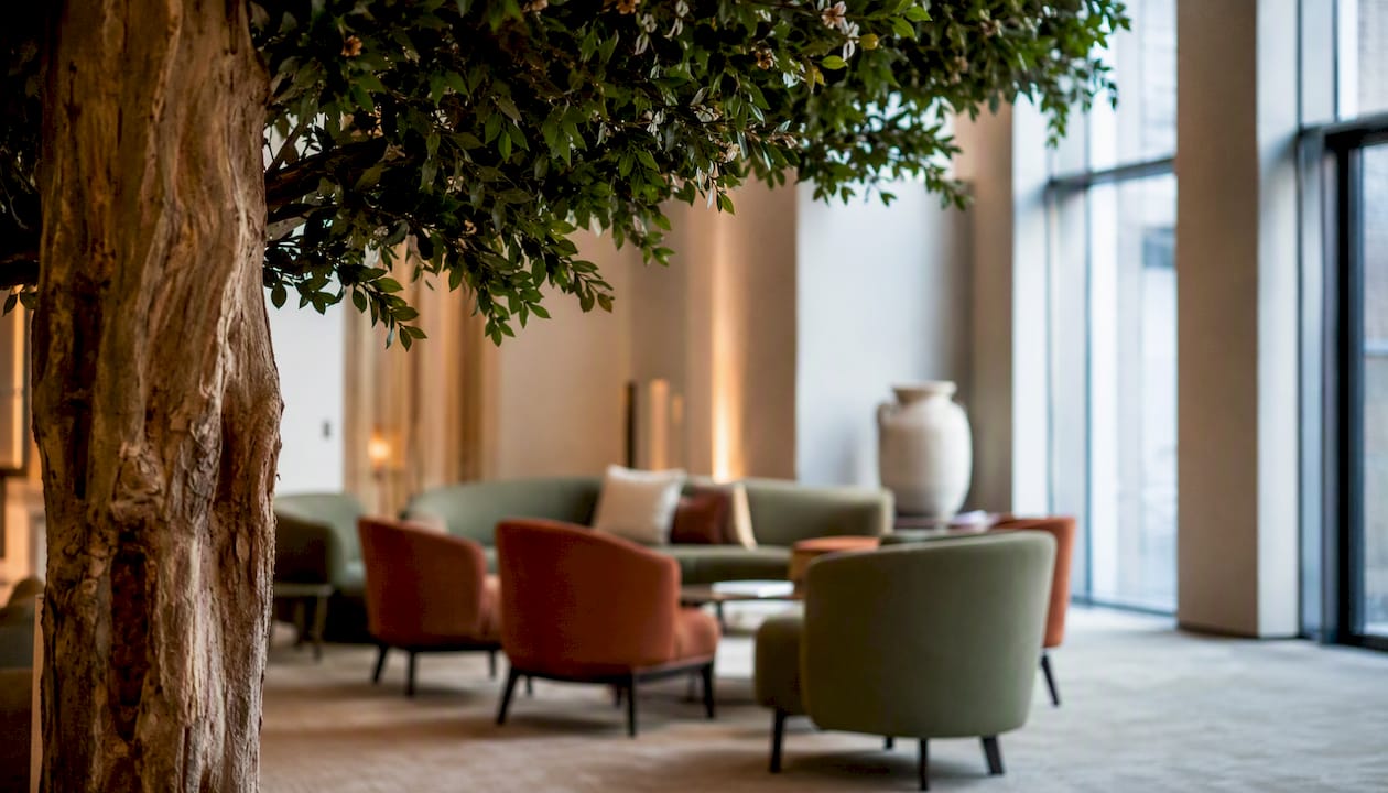 Im Eck der Hotellobby steht ein künstlicher Azaleenbaum aus Holz und sorgt für einen dekorativen Blickfang.
