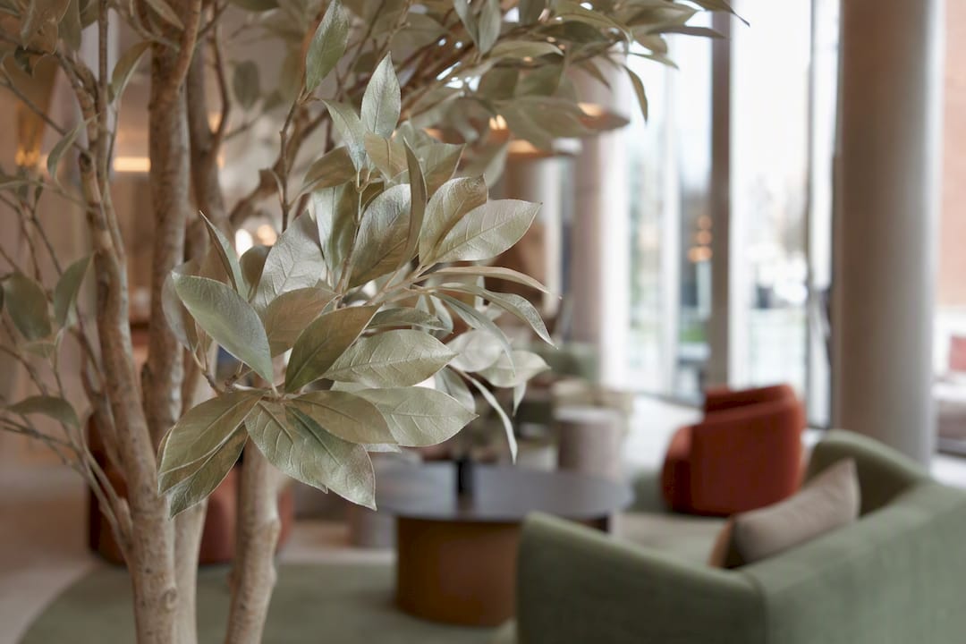 Hotelinnenraum mit realistisch wirkenden künstlichen Bäumen